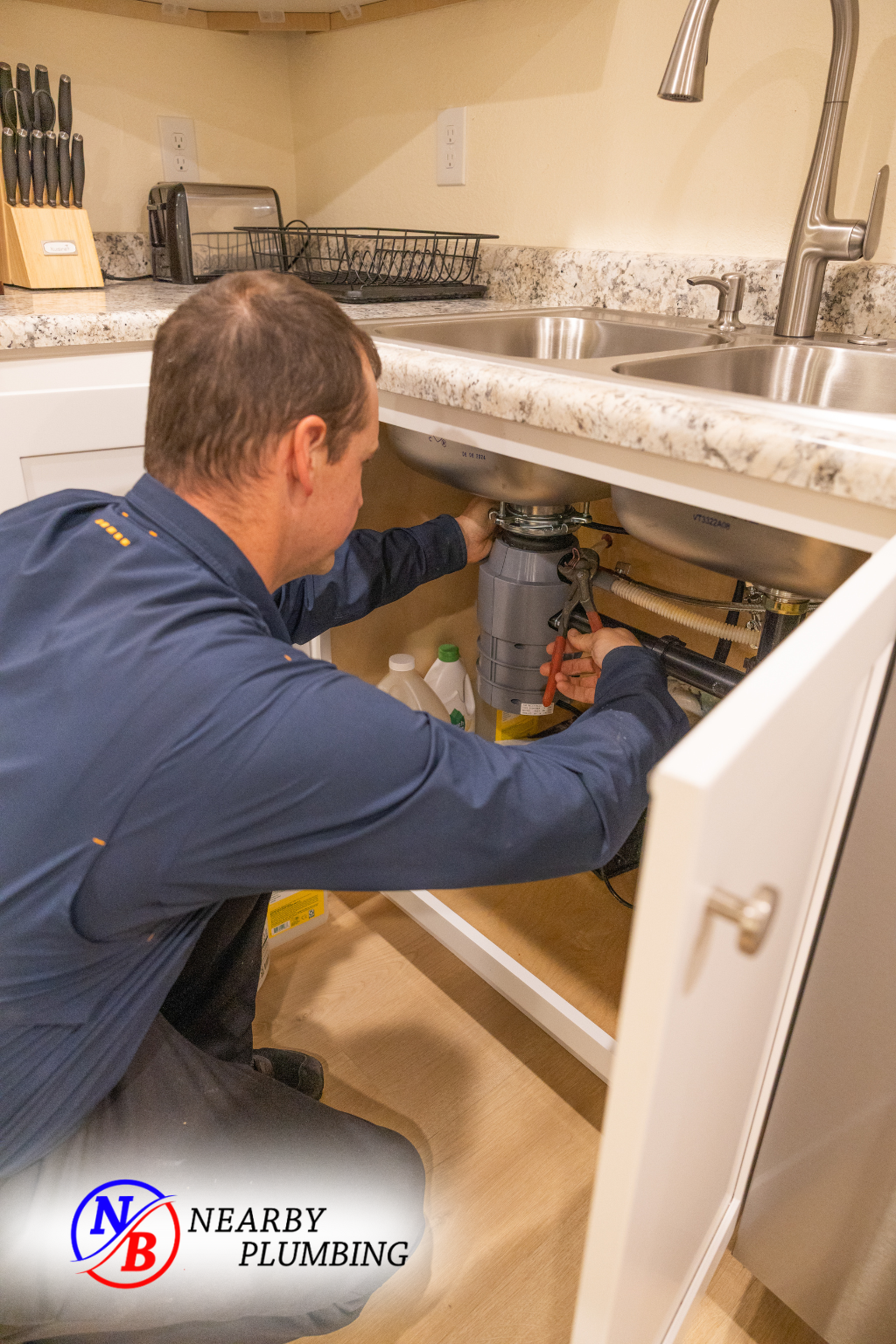 A Nearby Plumbing plumber repairing a kitchen sink drain